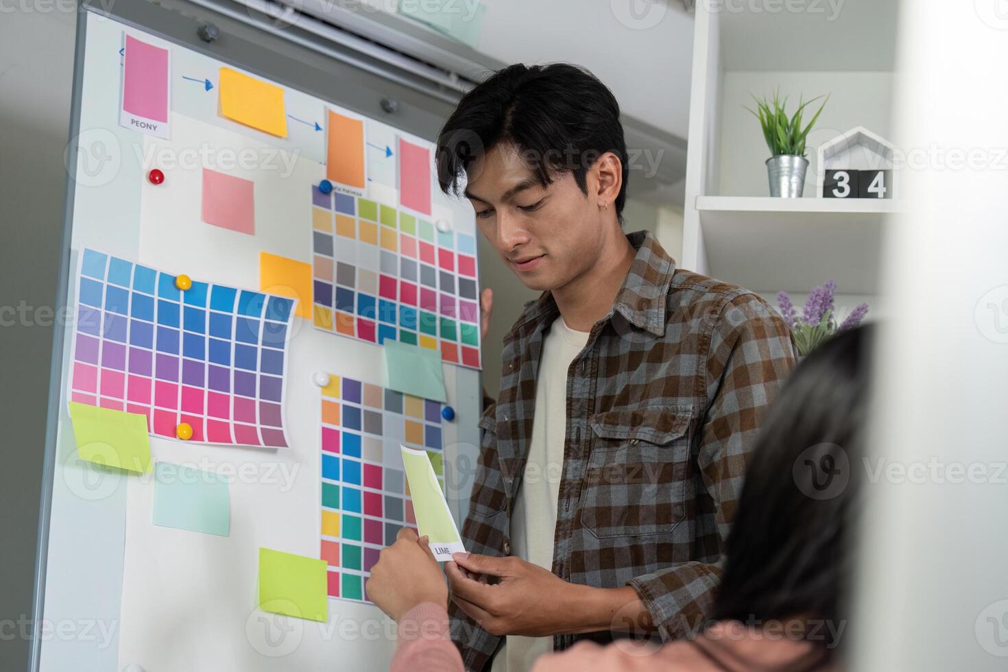 Diverse graphic design team member presenting color options for project discussion. photo