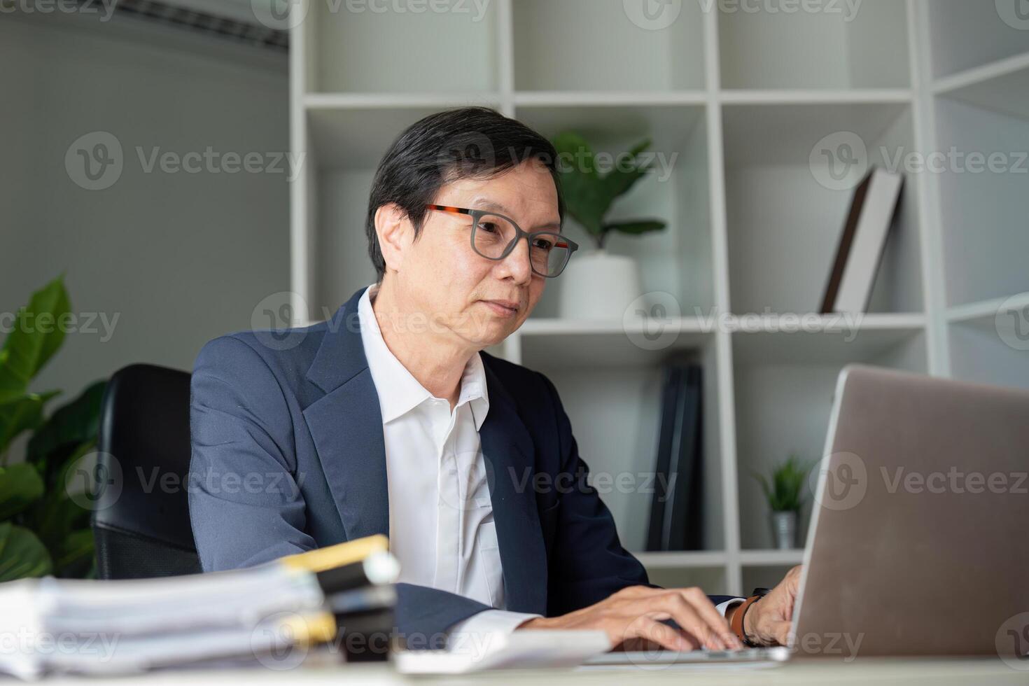 Elderly businessman working in modern office engaged in digital tasks professional environment focused viewpoint photo