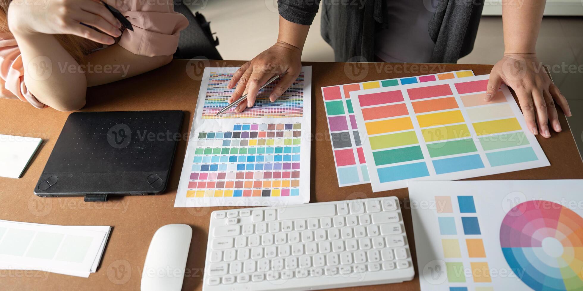 Graphic design team analyzing color palettes and materials in a collaborative workspace. photo