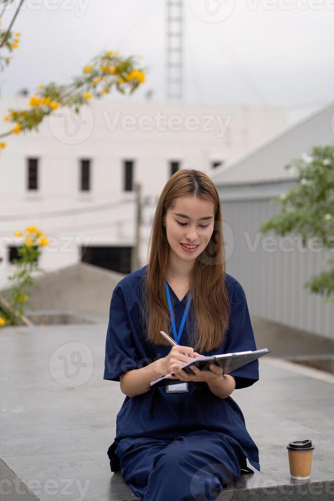 Young female doctor reviewing notes outdoors with a coffee, promoting relaxation and focus in healthcare photo