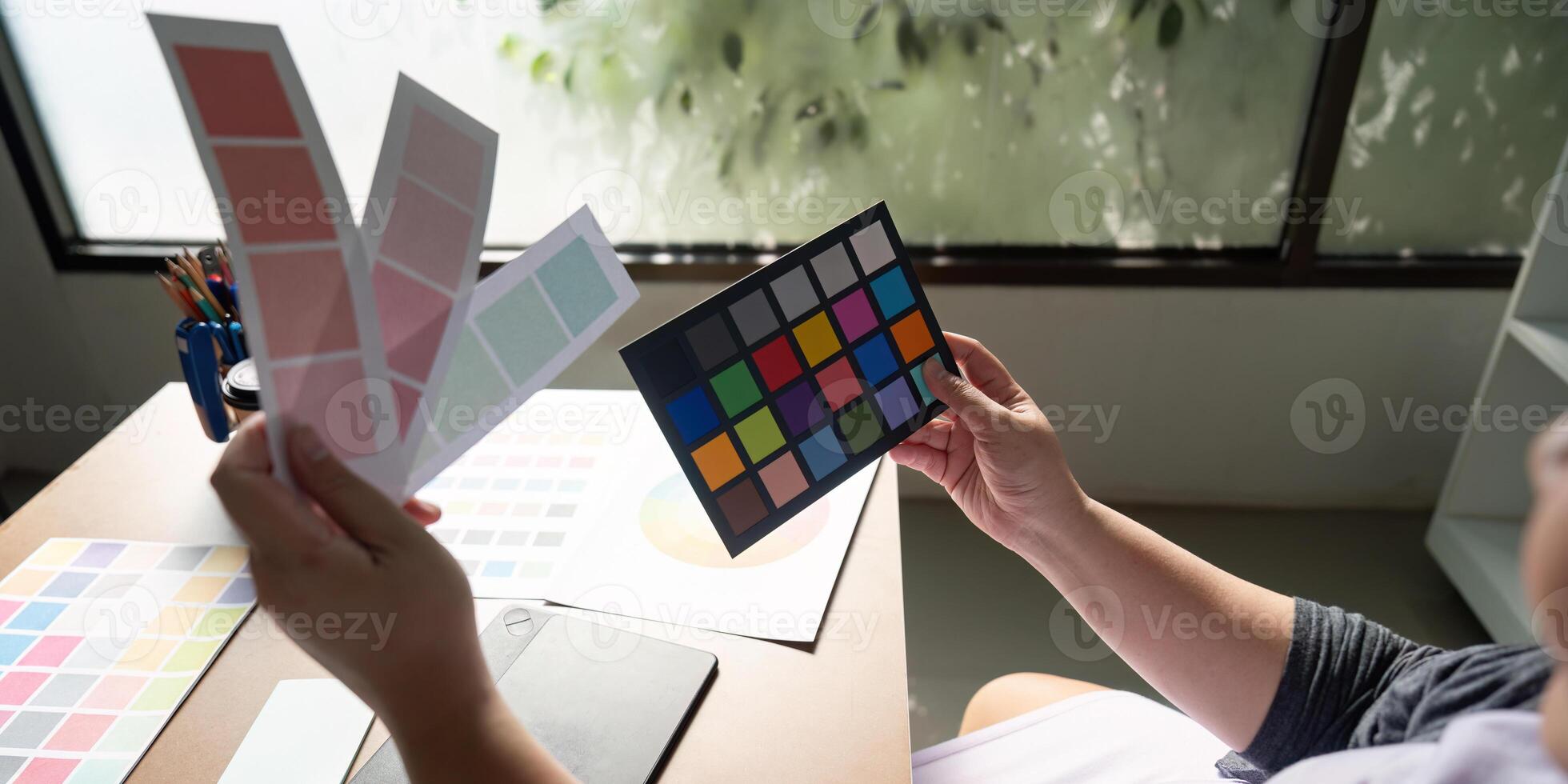 Graphic designer analyzing color palettes and samples at a creative workspace. photo