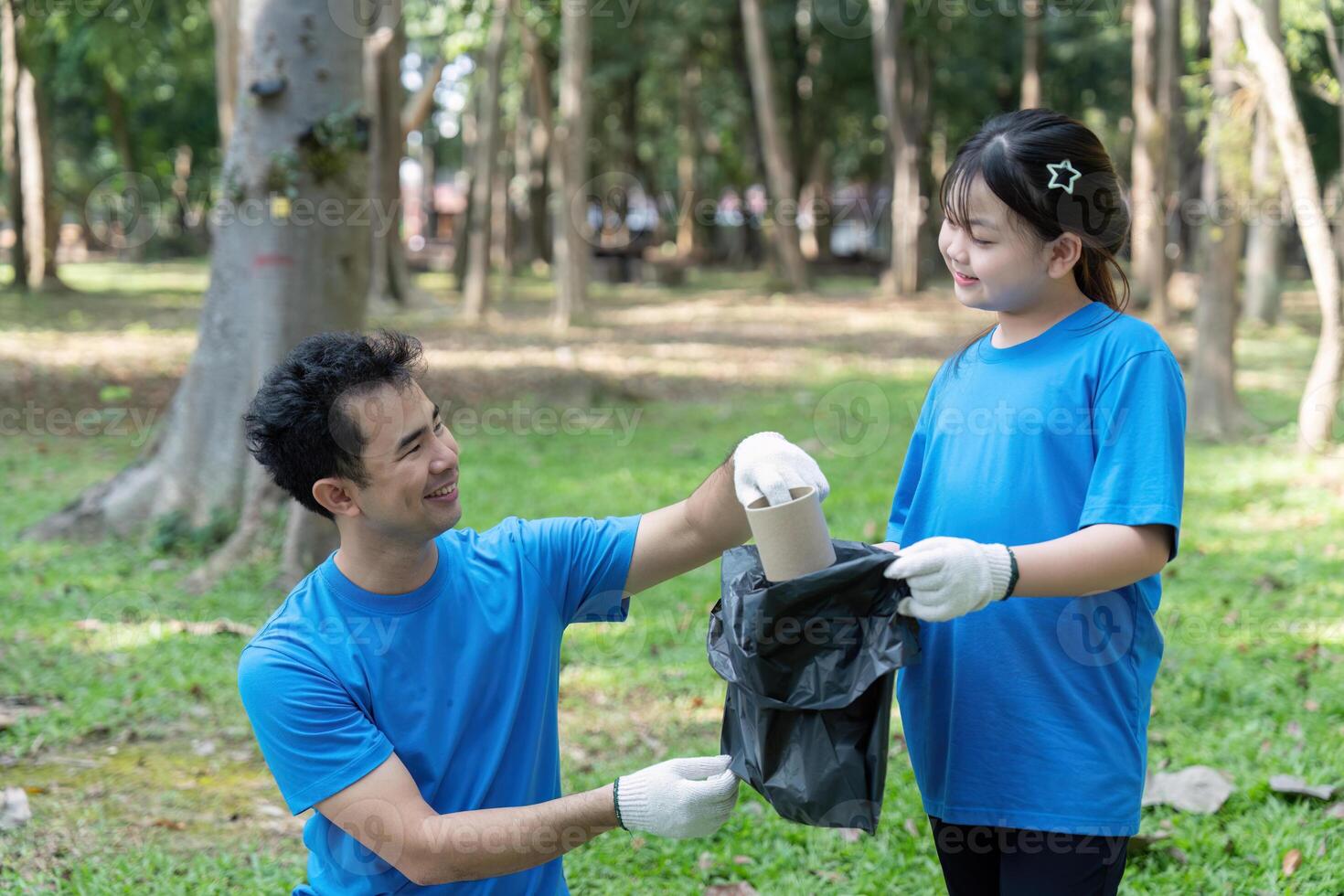 Family members volunteering for garbage collection in a park, encouraging environmental responsibility and teamwork. photo