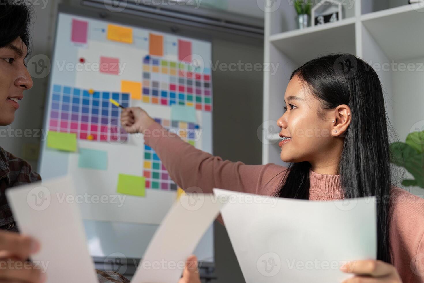 Diverse graphic design team discussing color palettes and project ideas. photo