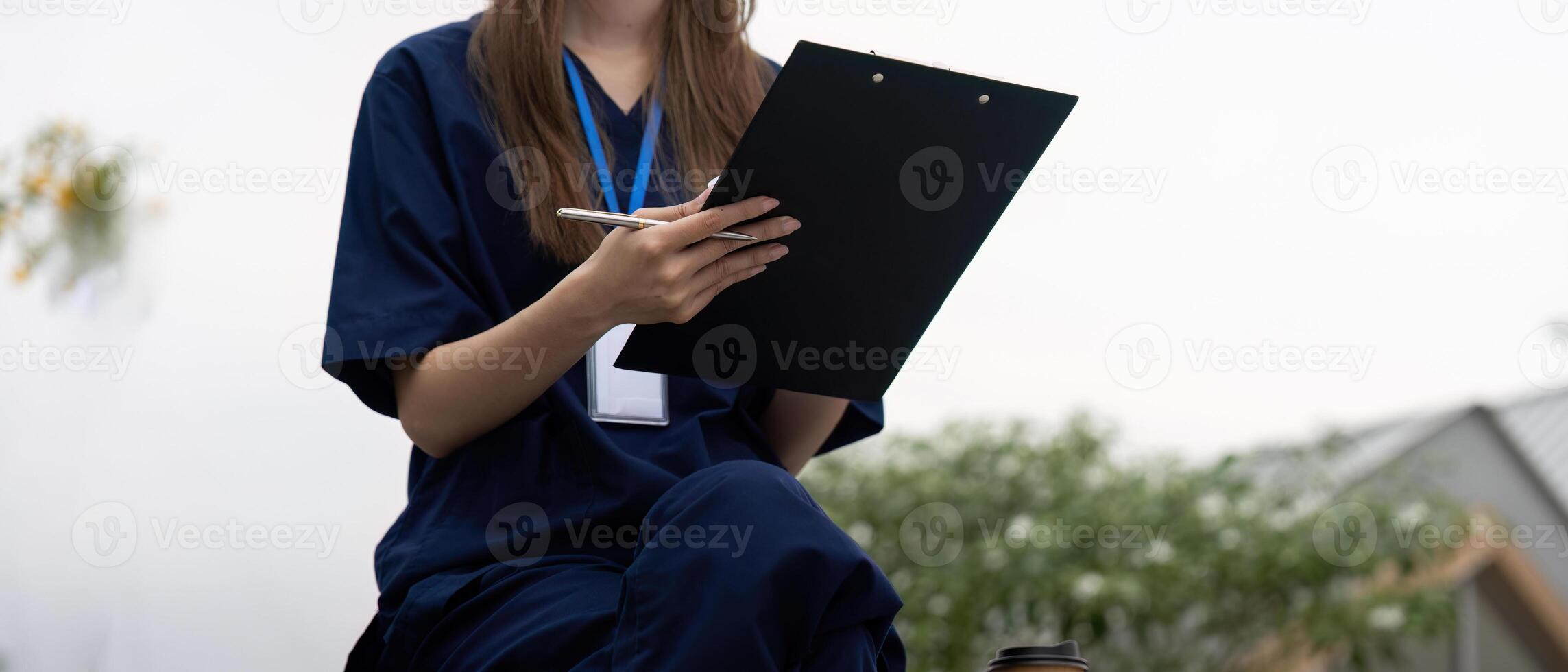 Nurse taking notes on a clipboard during a break in healthcare photo
