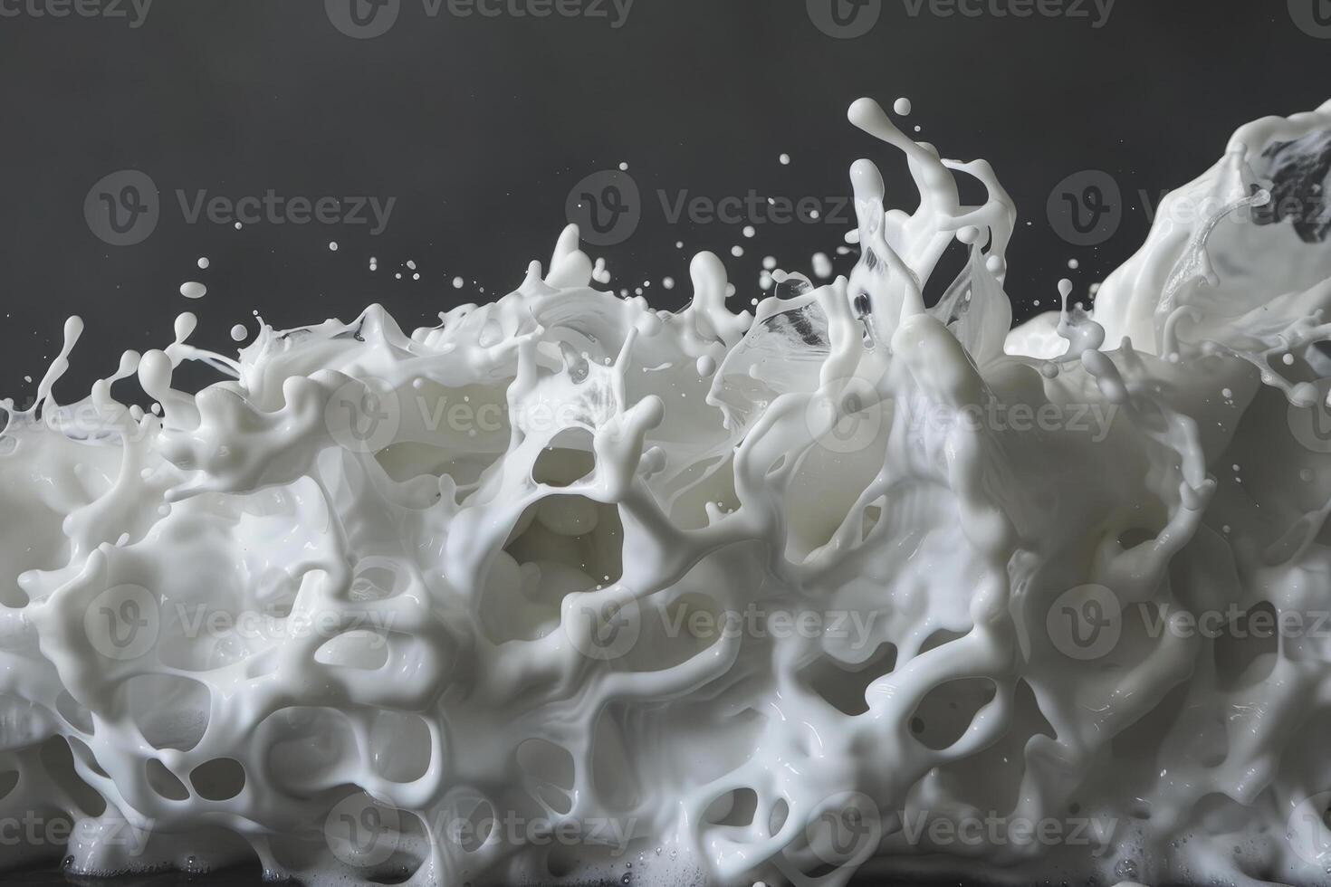 A vigorous display of white liquid erupts with splashes and droplets against a contrasting dark backdrop, showcasing an abstract and swirling texture photo