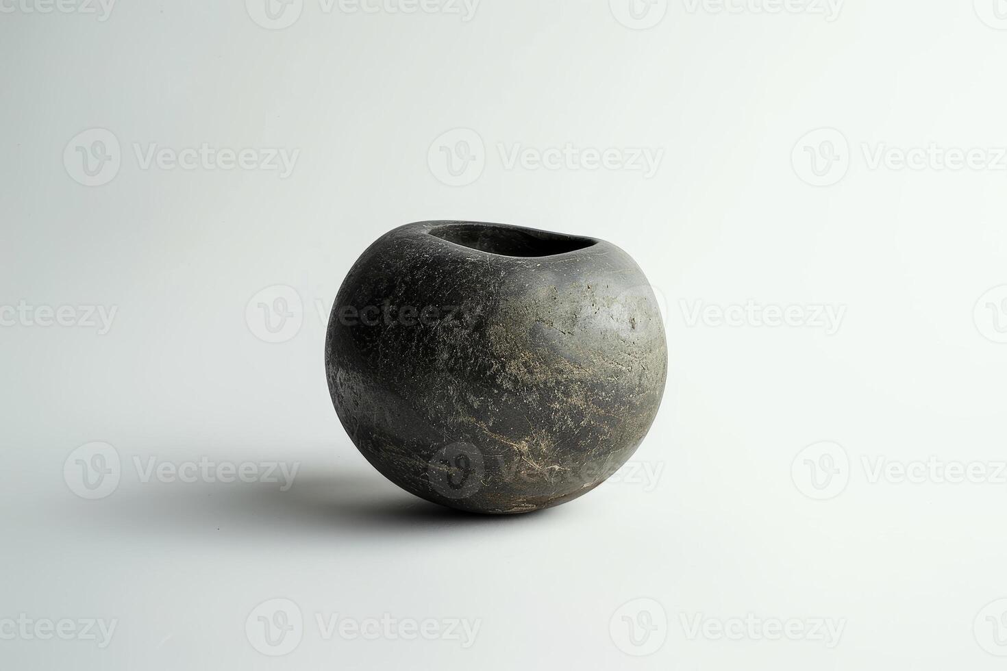 This decorative black stone vessel features a smooth, rounded form and an irregular opening, designed to enhance any space with its elegant simplicity and natural beauty photo