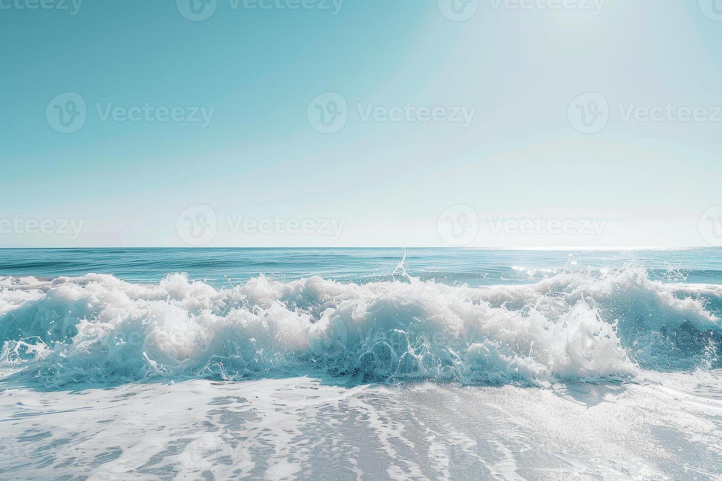 Gentle waves roll onto a sandy beach, creating a peaceful atmosphere. The sun shines brightly, reflecting off the water's surface, enhancing the tranquil scene photo