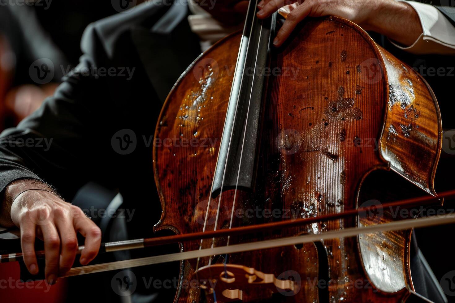A man playing a cello with a black bow photo