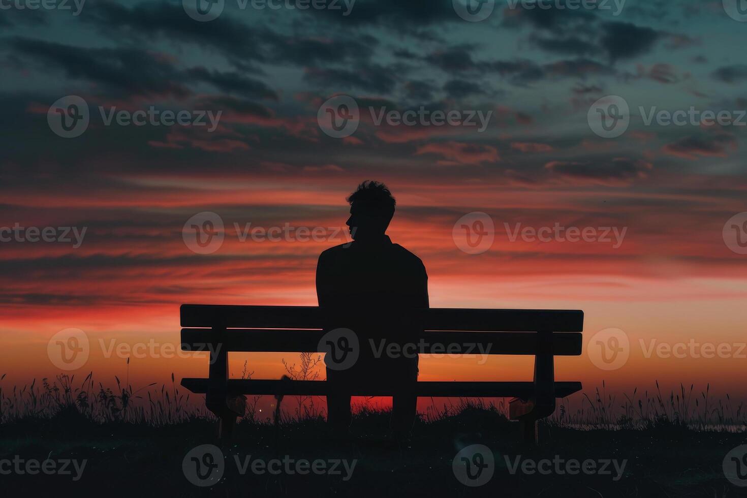 A person sitting on a bench at sunset photo