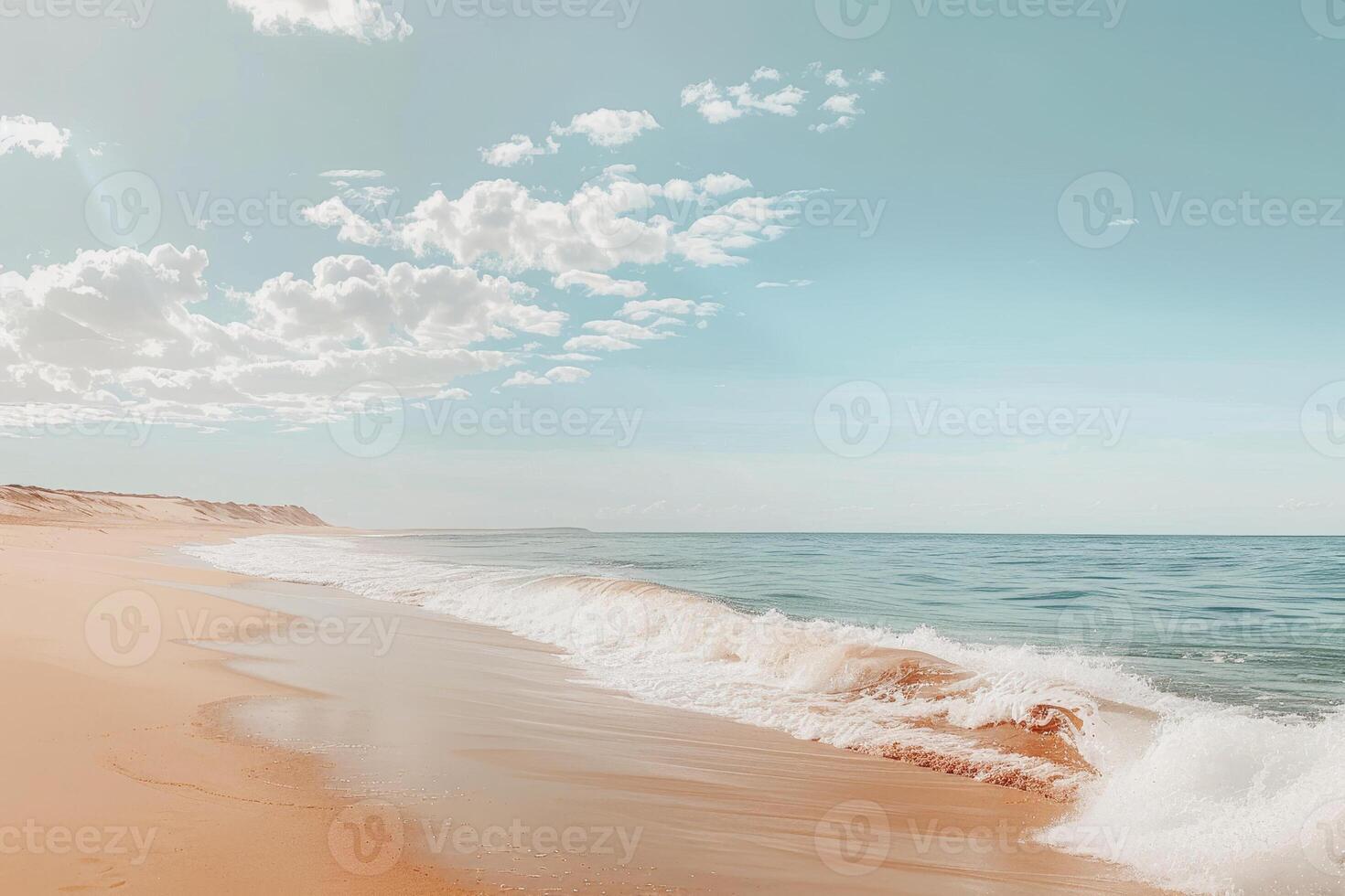 A sandy beach with waves and a blue sky photo