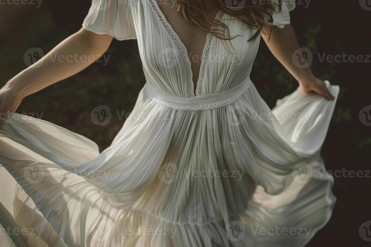 A woman dances joyfully in a delicate white dress, the sunlight illuminating the fabric as she twirls among lush greenery at dusk photo