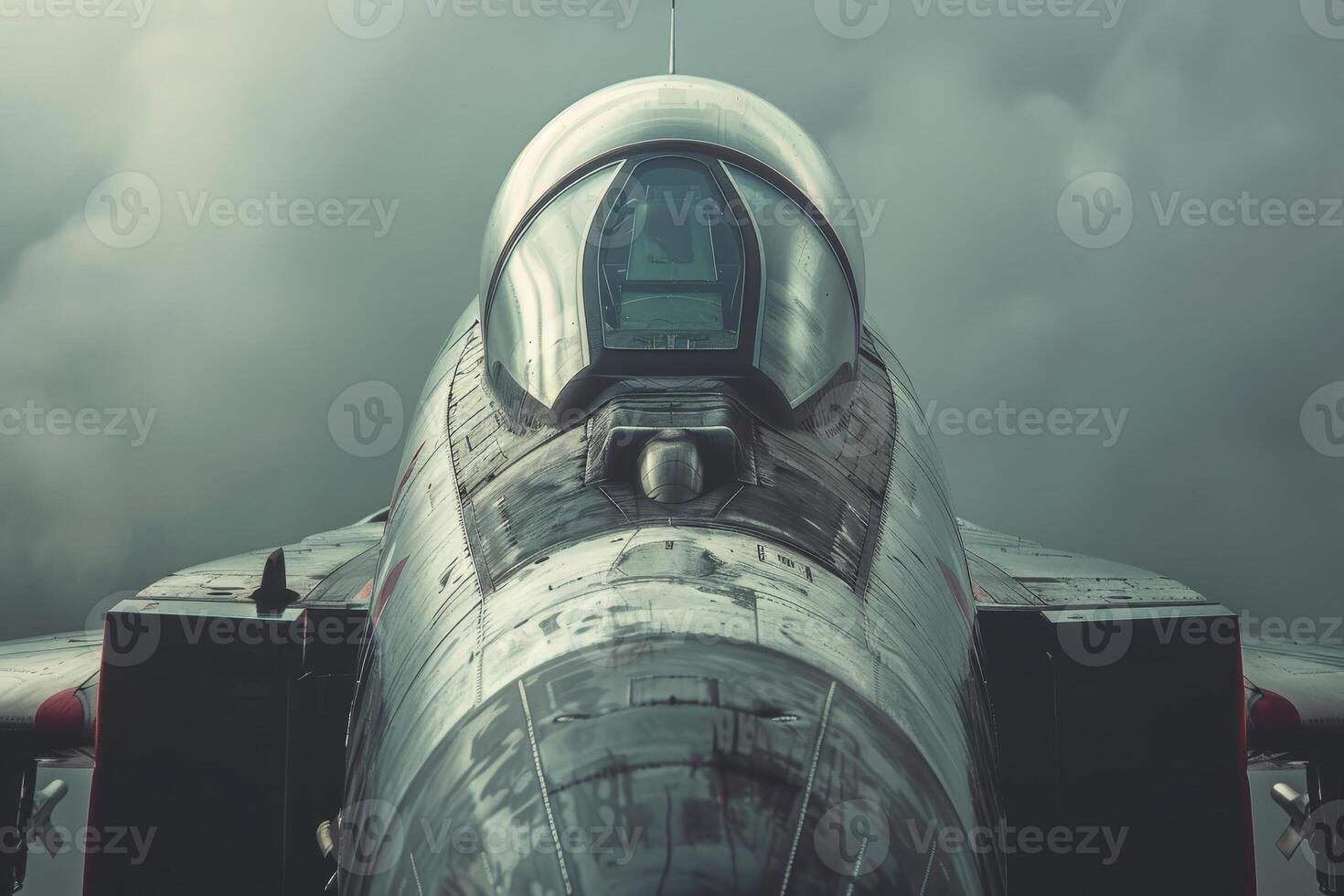 A fighter jet stands parked amidst dramatic clouds, highlighting its sleek contours and metallic finish, reflecting the power of military aviation photo