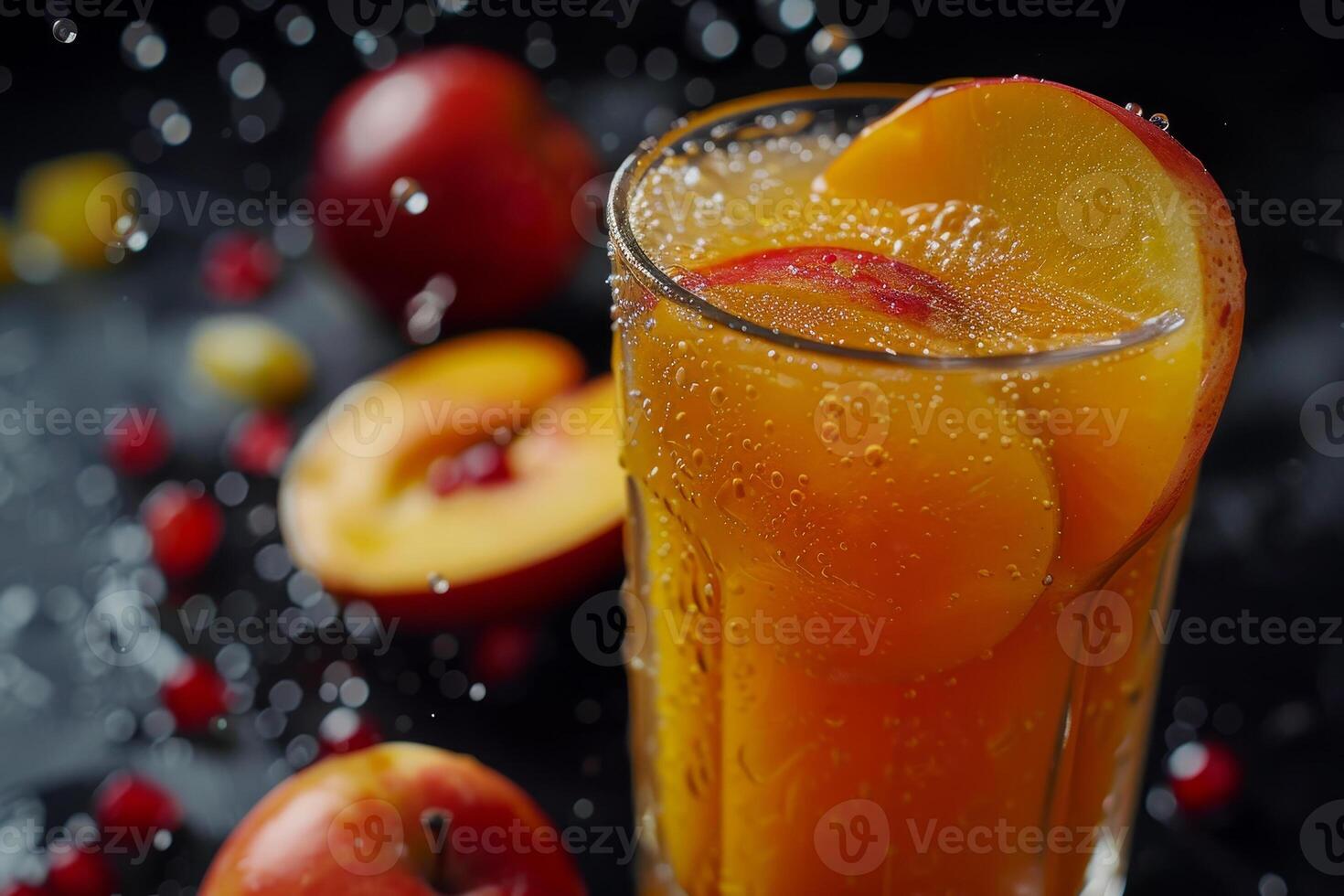 A tall glass filled with a bubbly peach and apple drink is adorned with juicy fruit slices. Surrounding the glass, fresh apples and droplets of water create a vibrant atmosphere photo