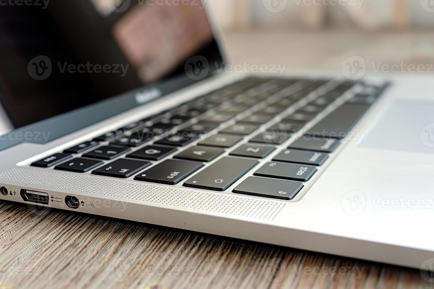 The keyboard of a modern laptop is displayed prominently on a wooden desk, highlighting its elegant design and functionality. The device appears ready for use photo