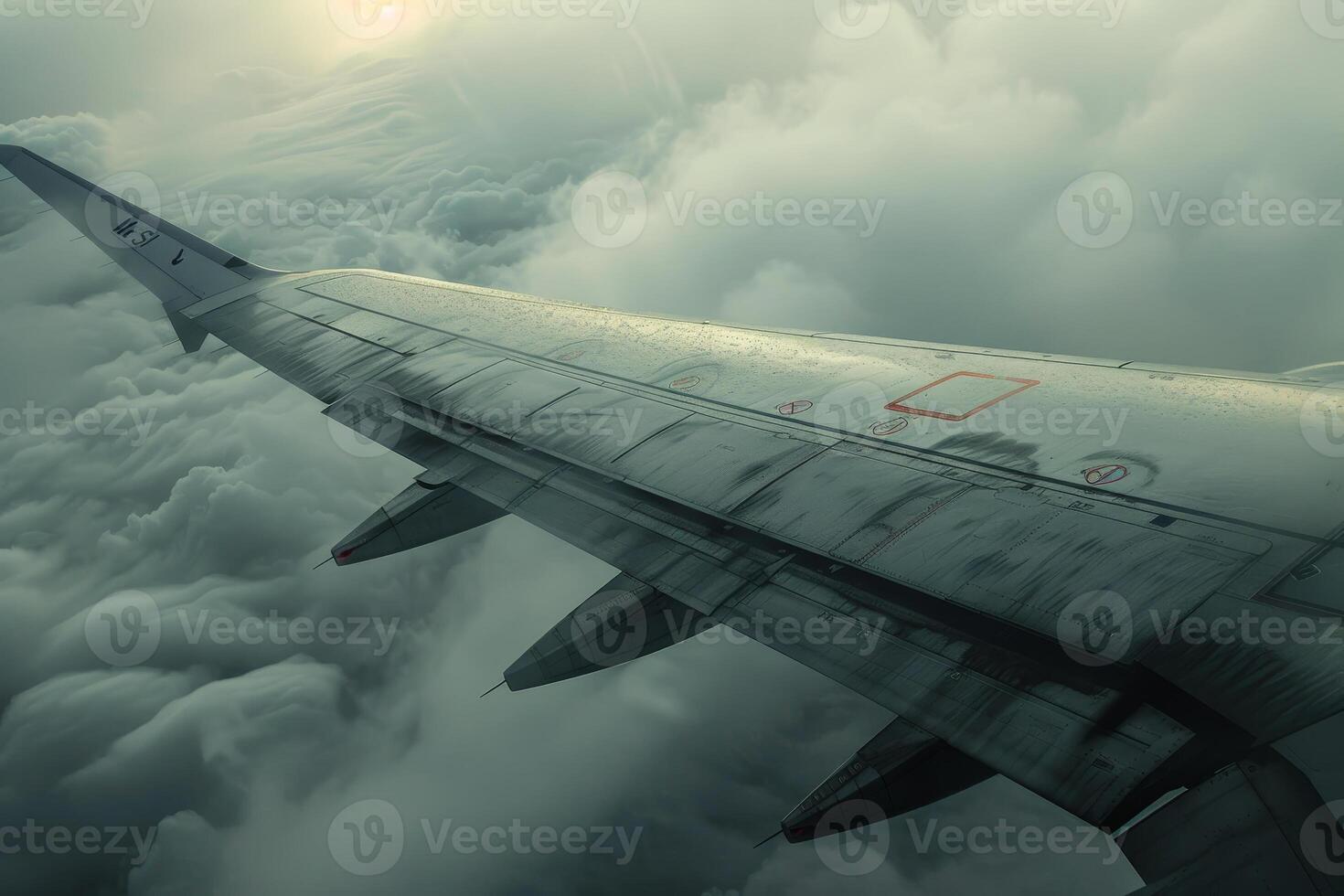 A view of the wing of an airplane flying through the clouds photo