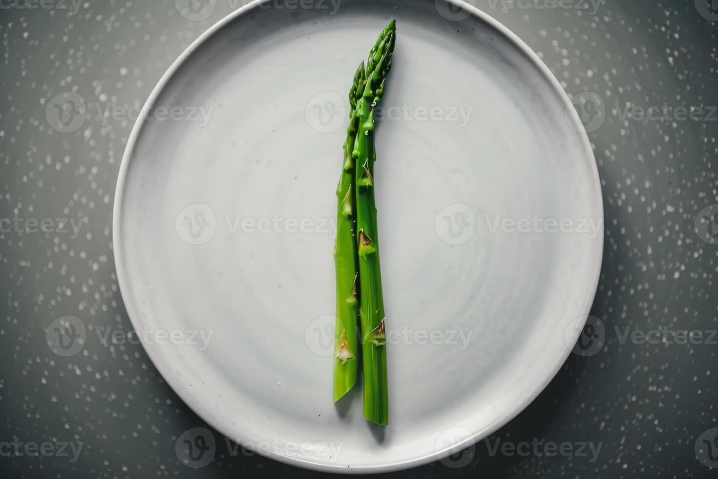 Bright green asparagus is arranged neatly on a plain white plate, showcasing its vibrant color against a textured, softly lit backdrop, emphasizing freshness photo