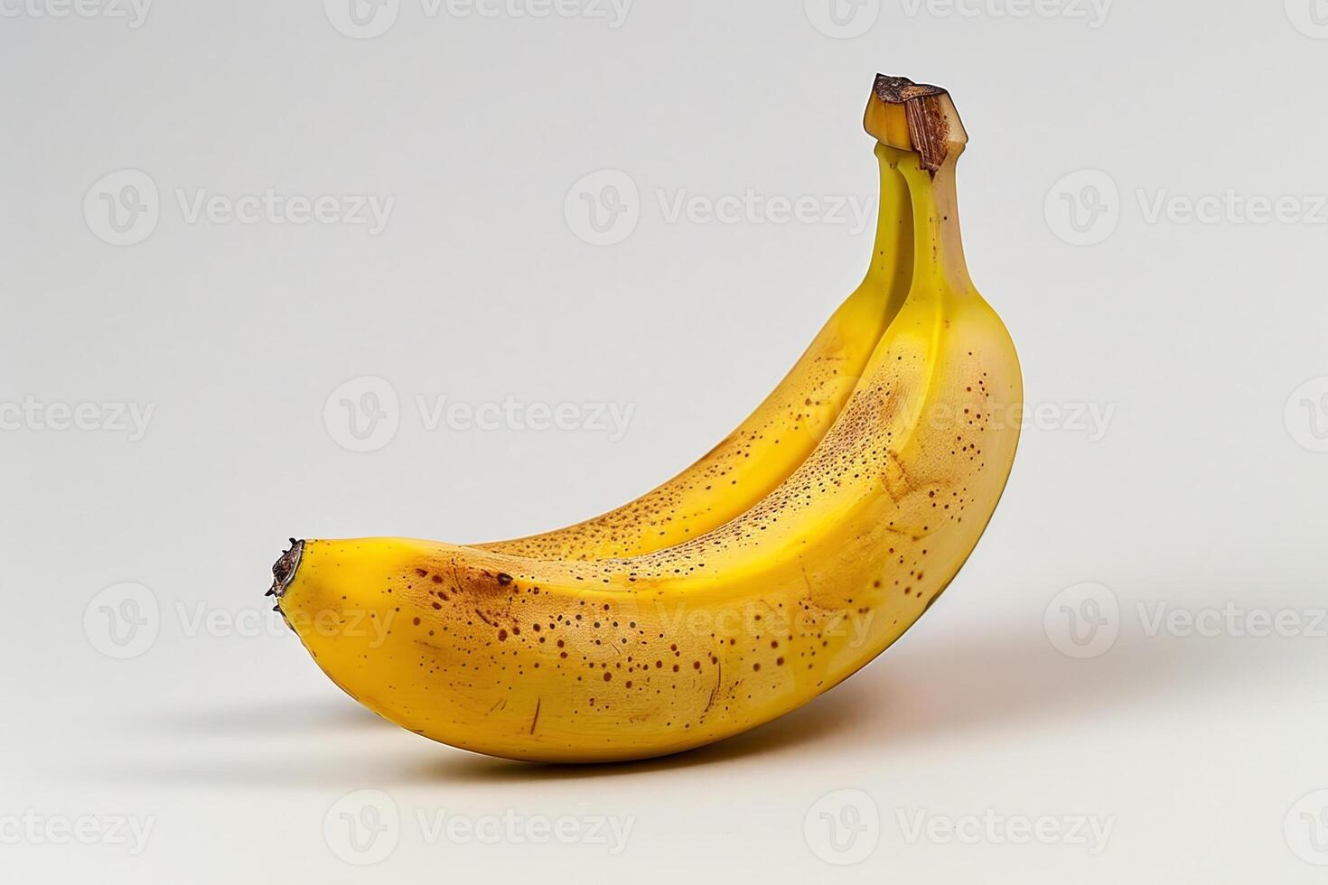 A single ripe banana with a bright yellow peel sits against a light background, showcasing its natural spots, highlighting its readiness for consumption and nutritional value photo
