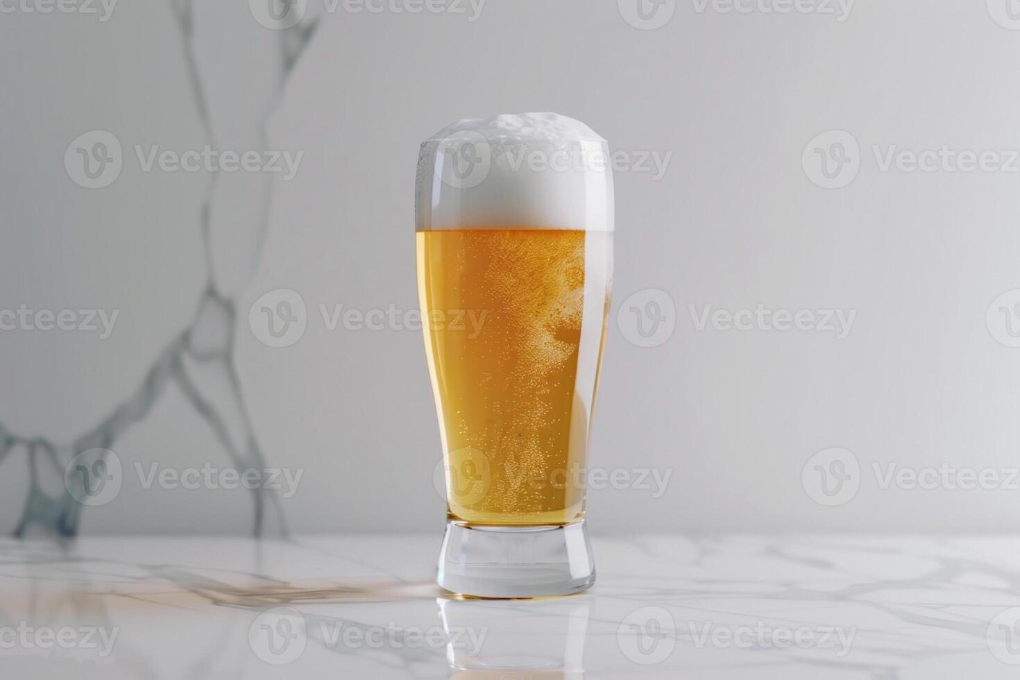 A clear glass filled with golden beer showcases a thick layer of creamy foam at the top, displayed on a sleek marble countertop in bright lighting photo