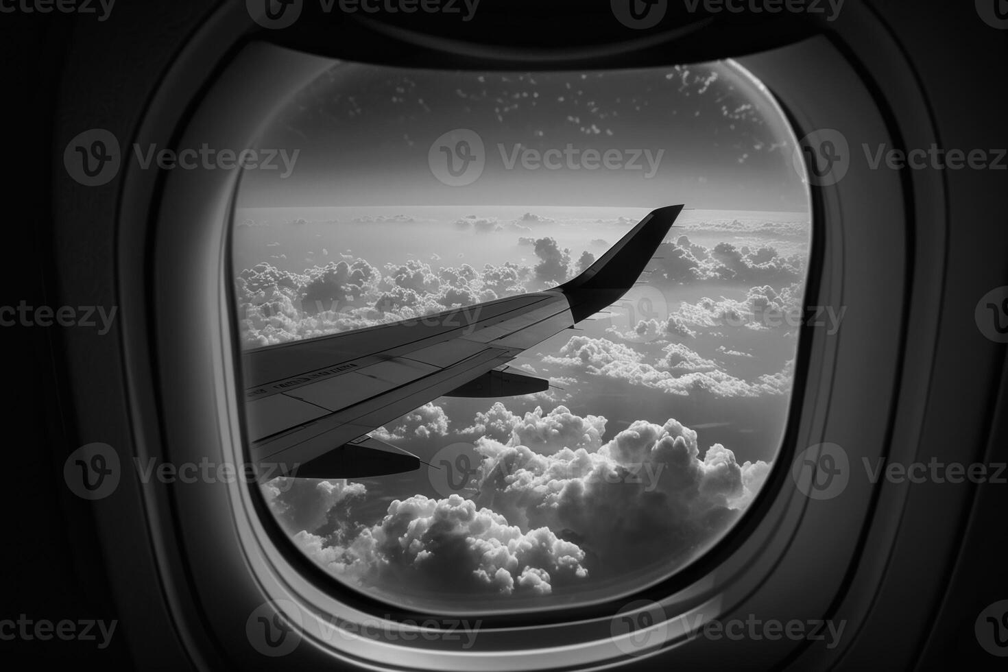 A passenger gazes out of an airplane window, witnessing the vast sea of clouds below. The wing extends into the frame, creating a serene and calming atmosphere photo