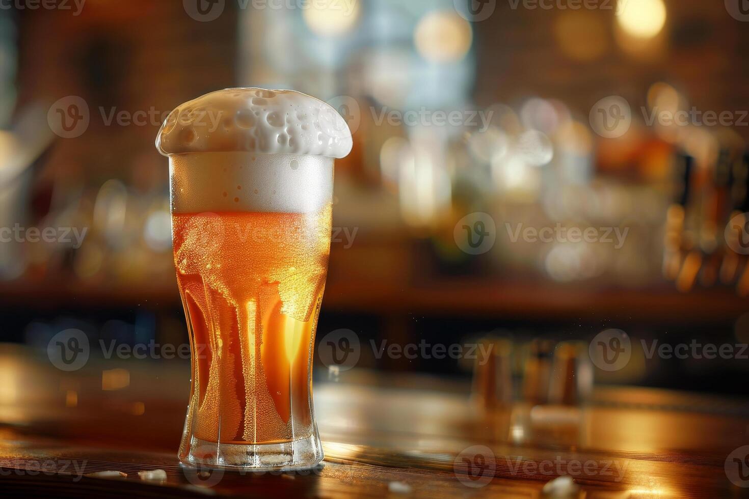 A chilled glass filled with golden beer showcases a thick, frothy head while being placed on a polished wooden bar. The warm glow of the pub enhances the inviting atmosphere photo