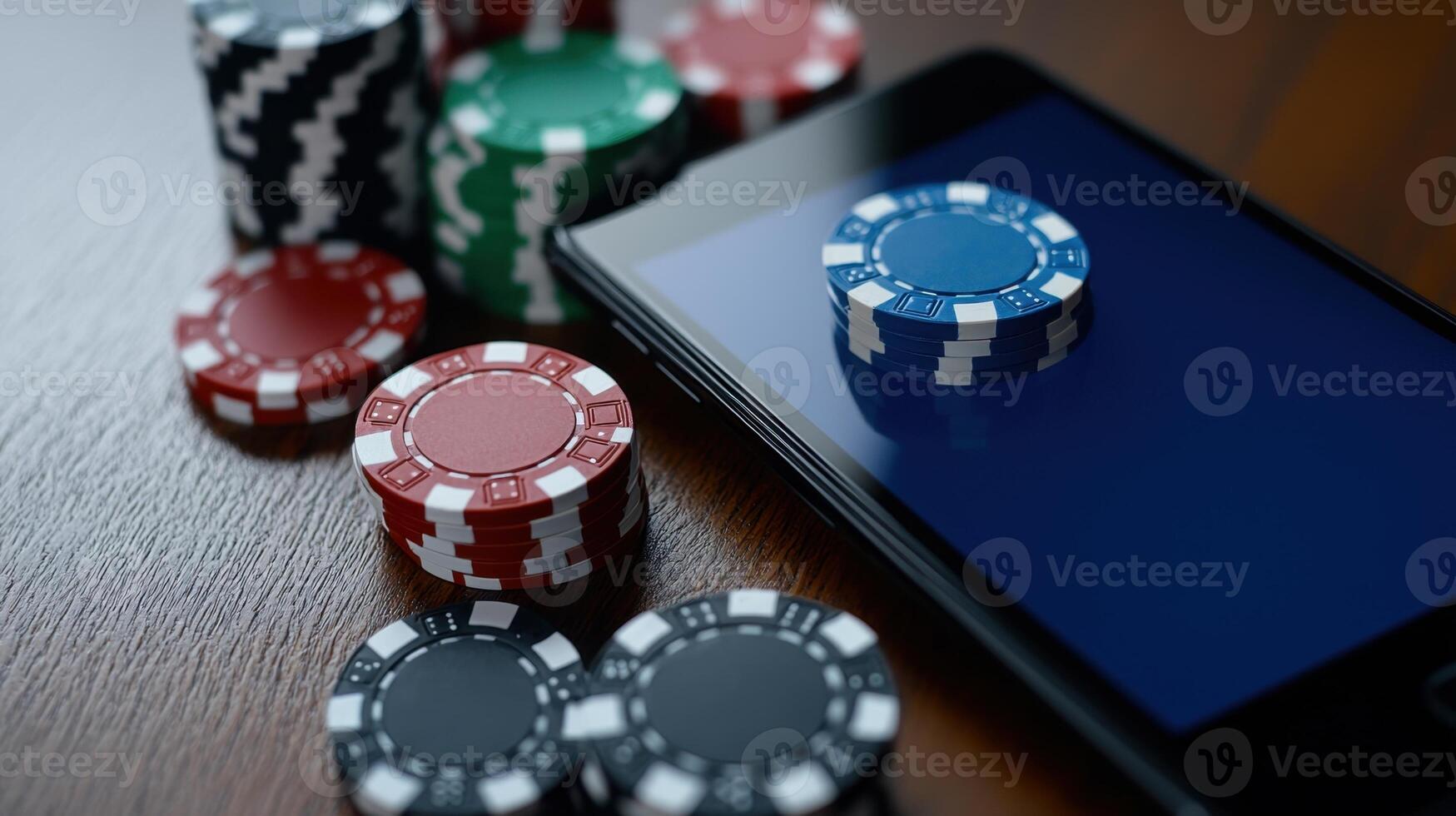 Poker chips of various colors are scattered around a smartphone displaying a gaming application. The setting is a well-lit indoor environment focused on mobile gaming photo