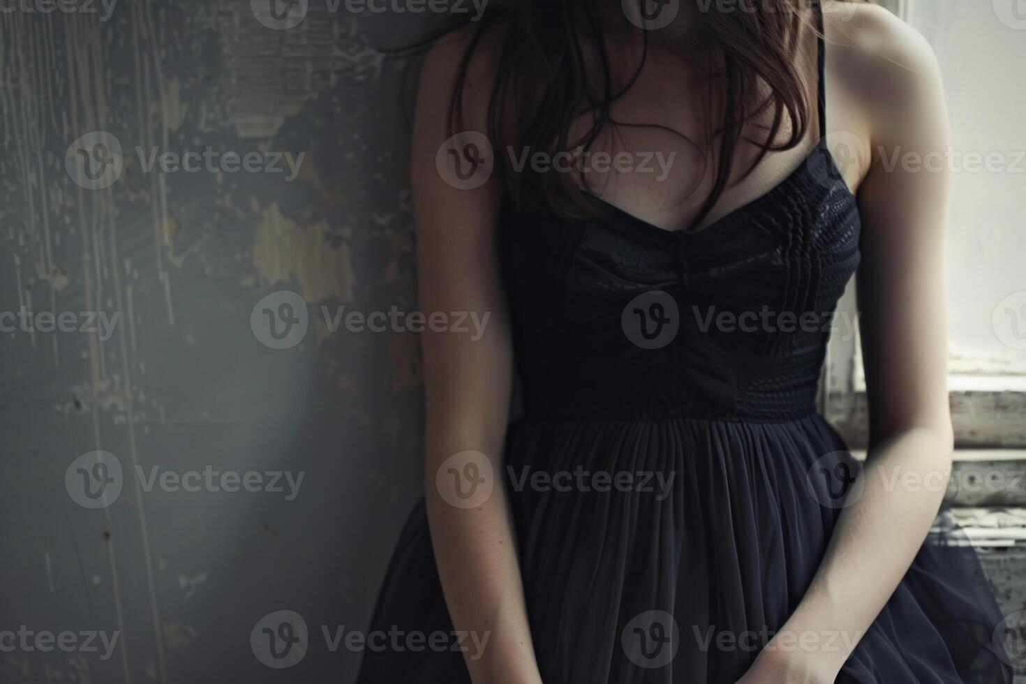 A woman in a black dress standing by a window photo