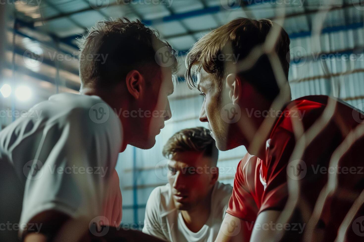 Three men sitting in a soccer net photo