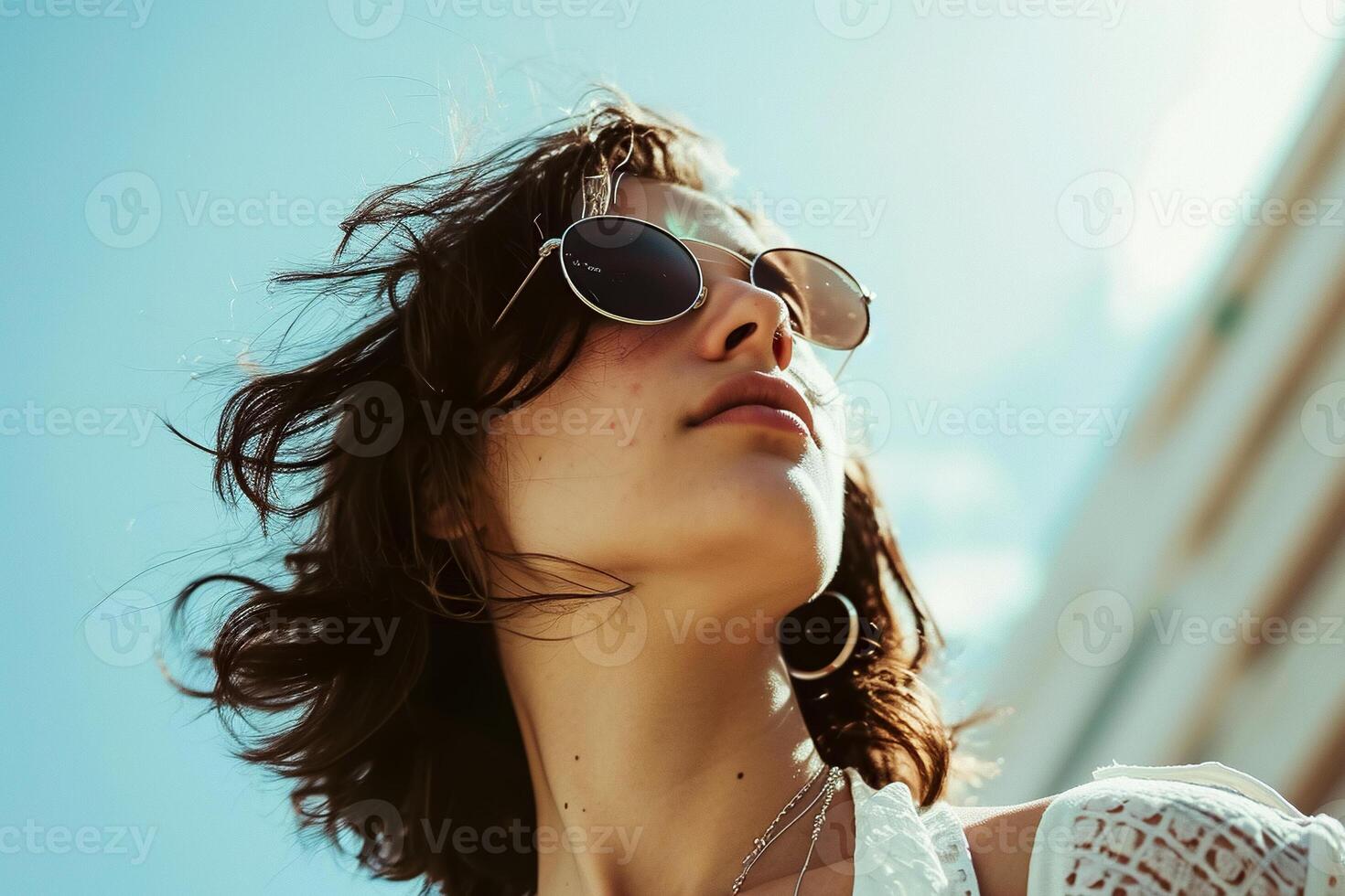 A woman wearing sunglasses and a white top photo