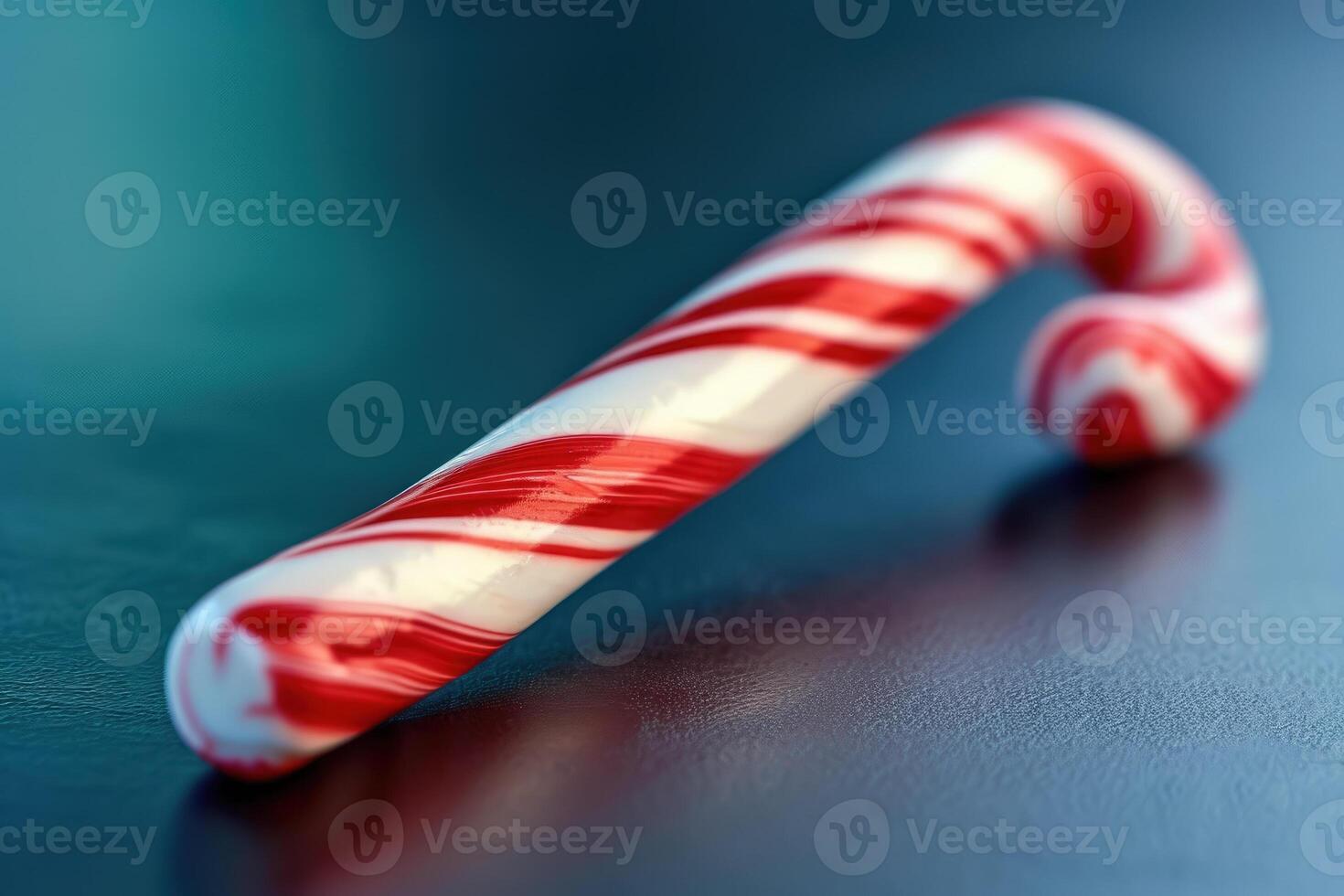 A candy cane on a table with a red and white striped candy cane photo
