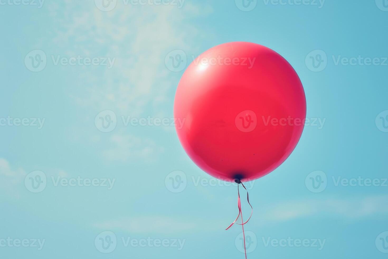 A red balloon is floating in the air photo