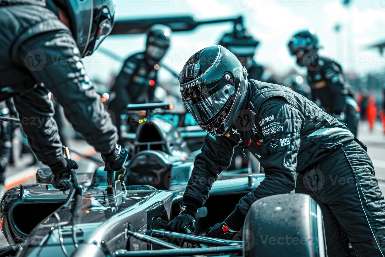 A group of men in black suits working on a race car photo