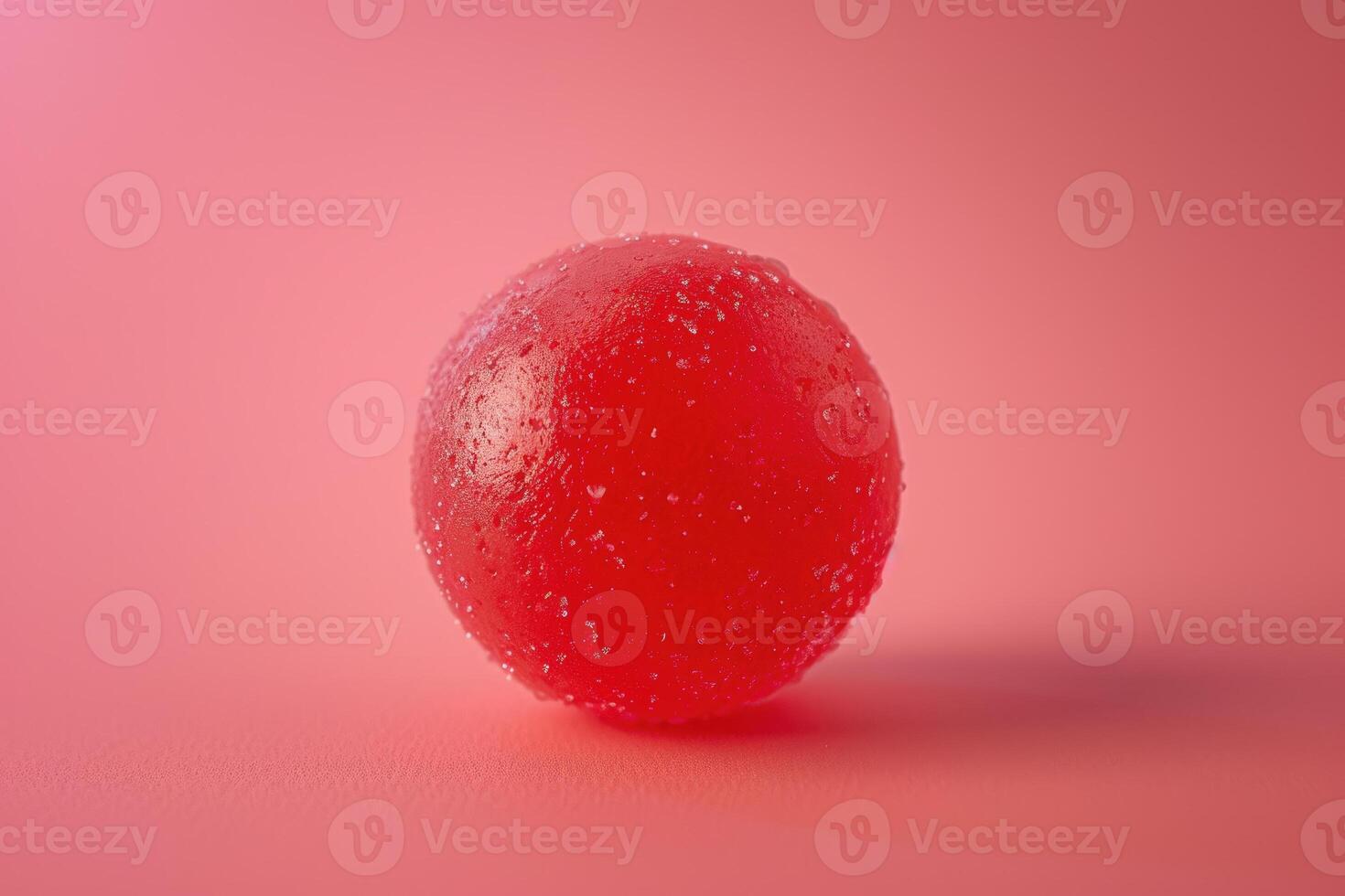 A red jelly ball on a pink background photo