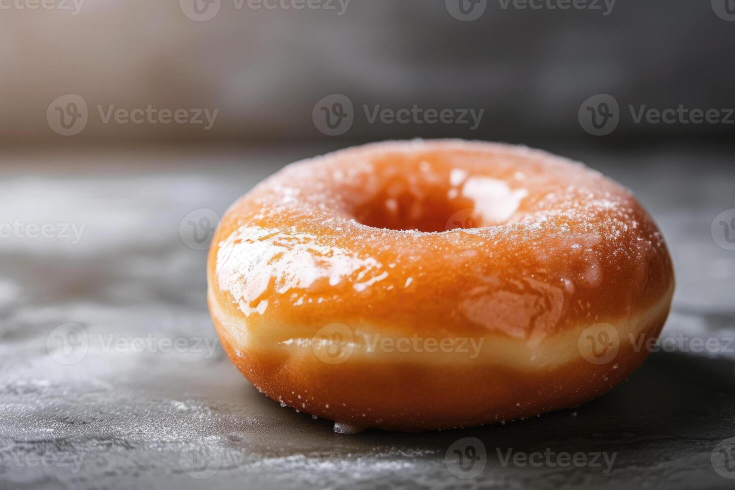 A single glazed doughnut sitting on a table photo