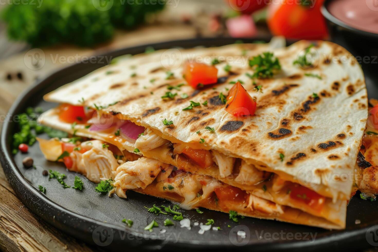 Chicken quesadillas with tomato and onion on a black plate photo
