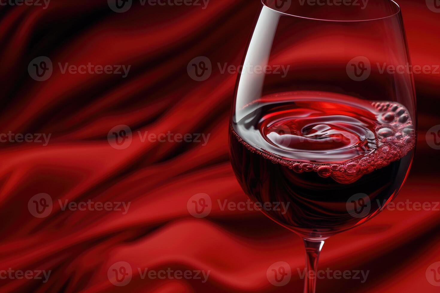 A glass of red wine on a red cloth photo