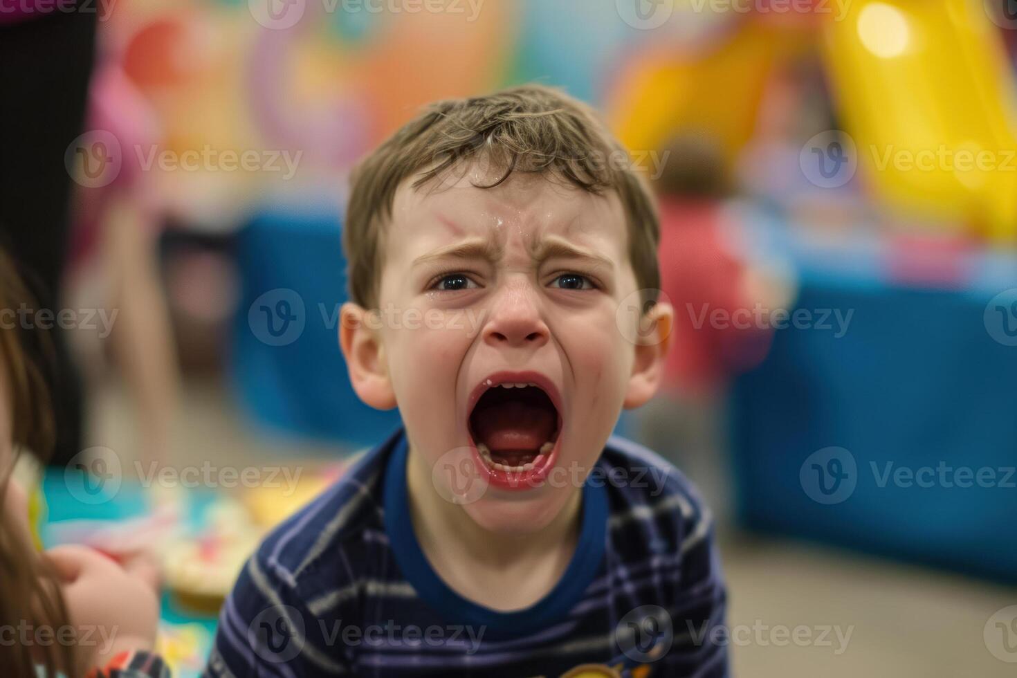 A young boy is crying while sitting on a table photo