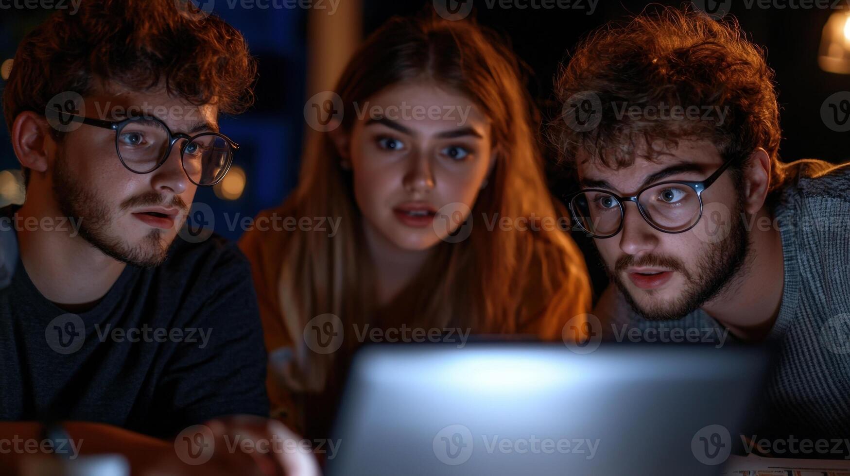 Three people are looking at a laptop screen photo