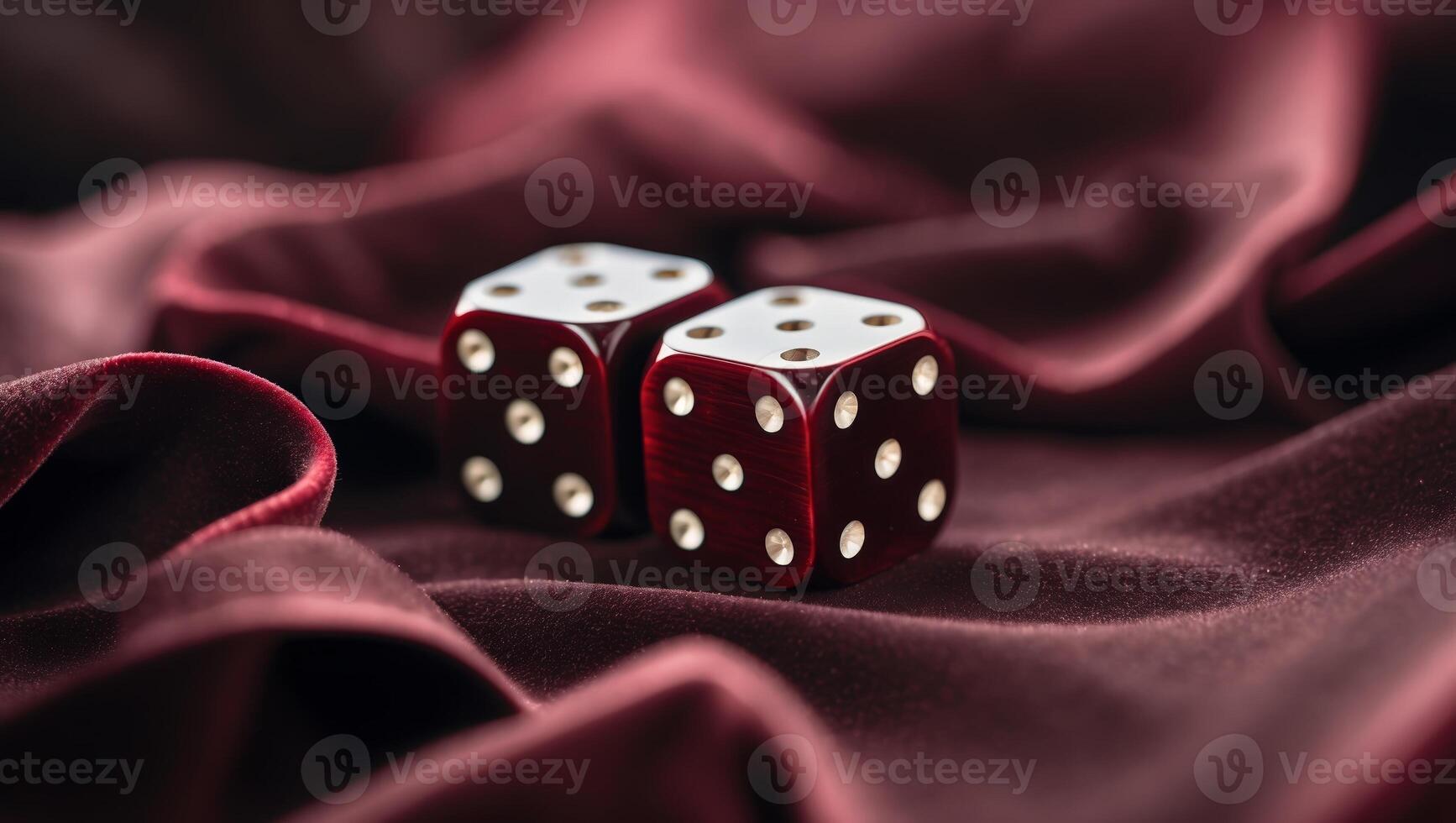 Two red wooden dice resting on luxurious burgundy fabric in an elegant setting photo