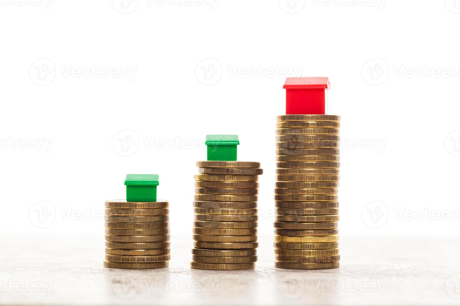 Stacks of coins, green and red home. Mortgage concept by money house from coins photo