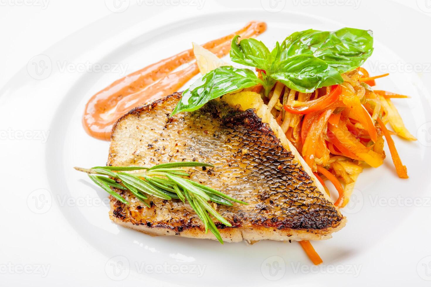 Dish of fish fillet with basil and lemon on plate isolated on white photo