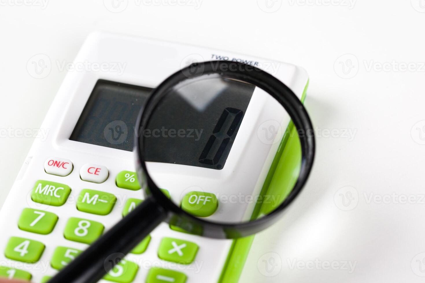 Calculator with a magnifying glass on a white background photo