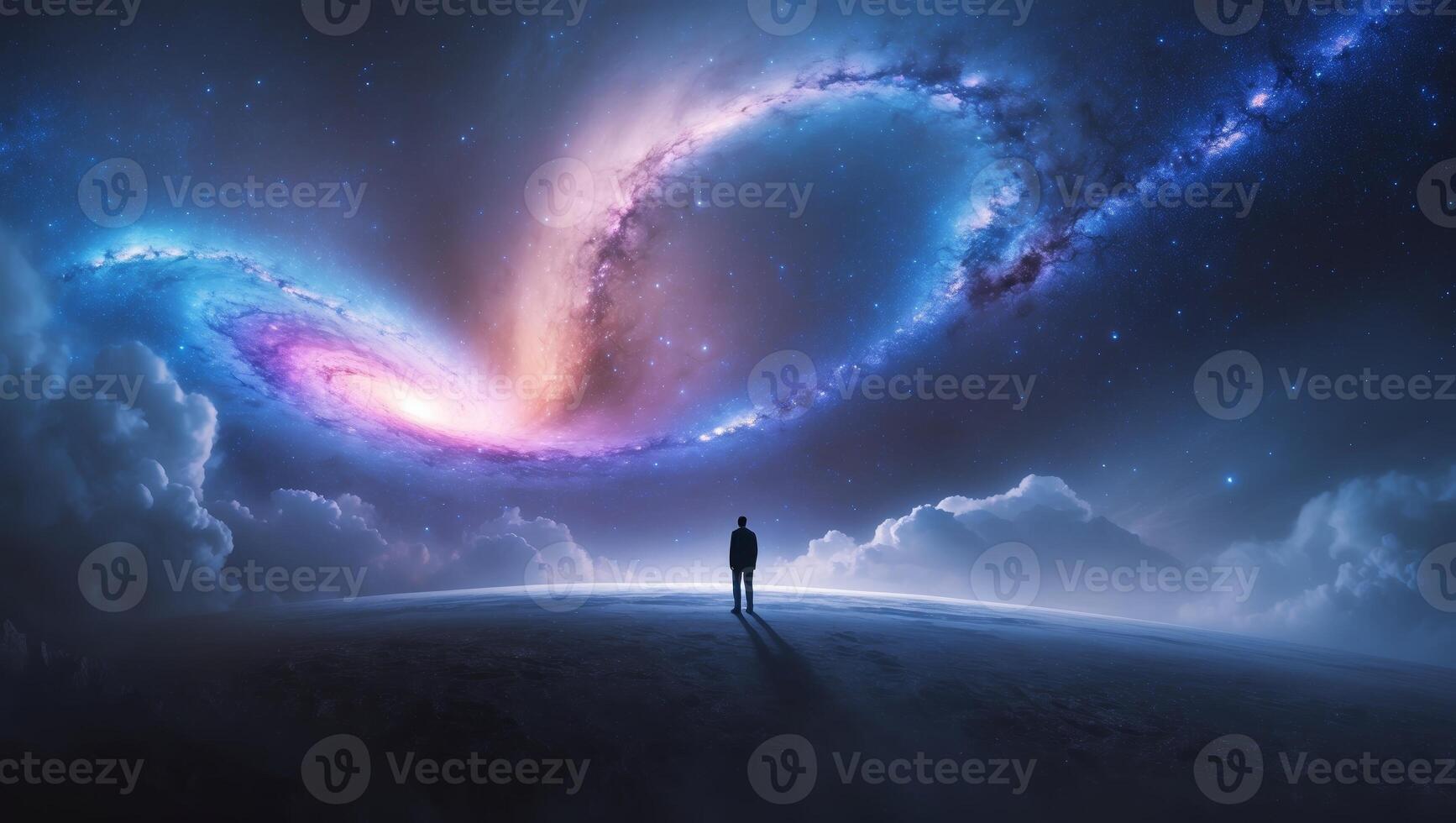 Person standing on an alien landscape gazing at a swirling galaxy in a starry sky photo