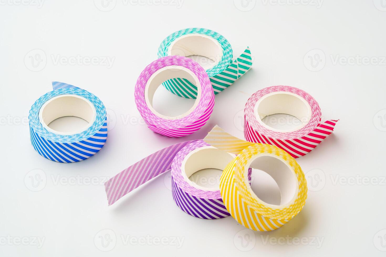 Colorful striped washi tape rolls arranged on a clean surface for craft and DIY projects photo