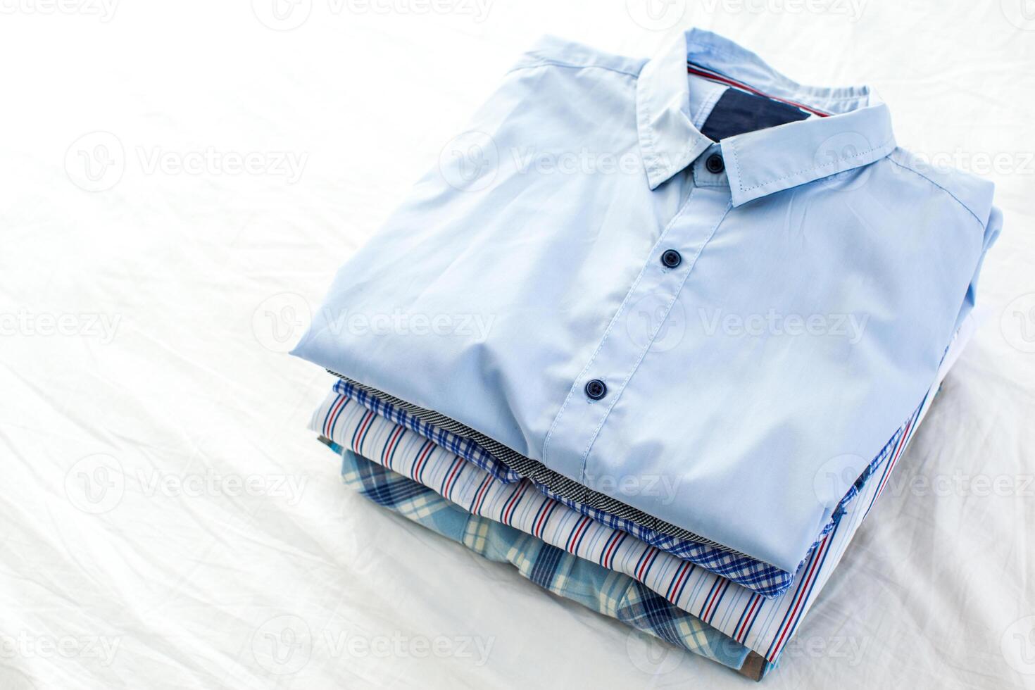 close up of ironed and folded shirts on table at home photo
