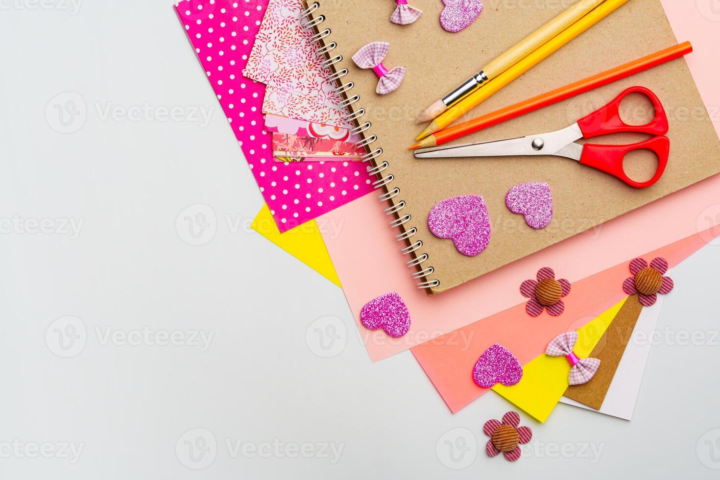 Craft supplies arranged with colorful paper, scissors, and decorations for DIY projects at a workspace photo