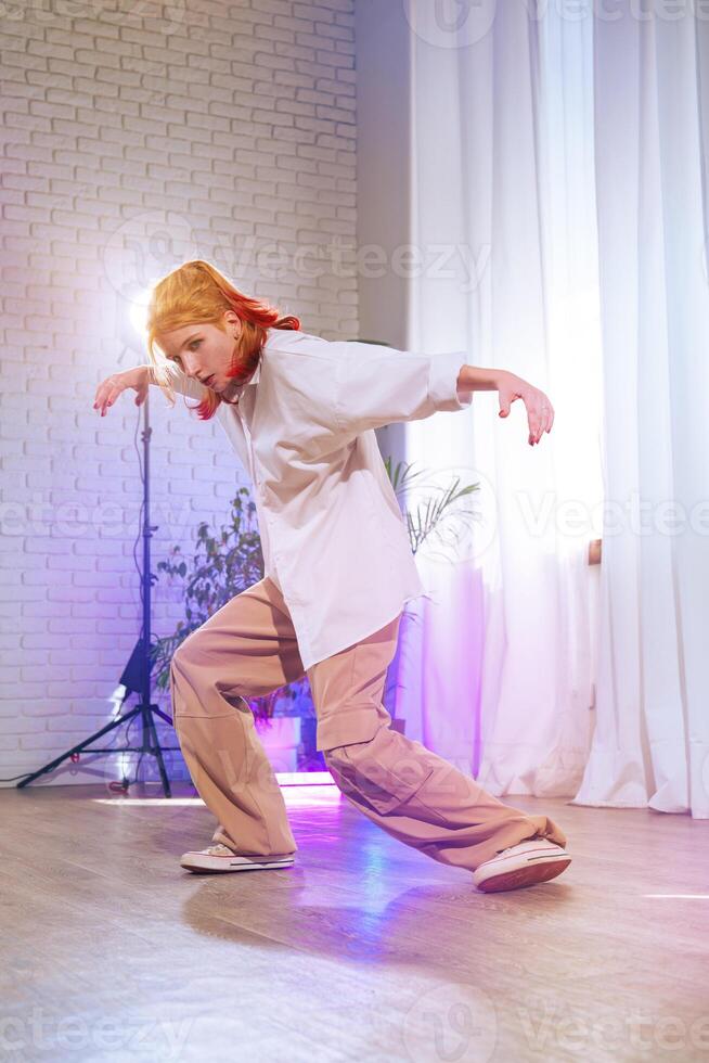 Dynamic dance performance in a modern studio featuring a young dancer with vibrant hair photo