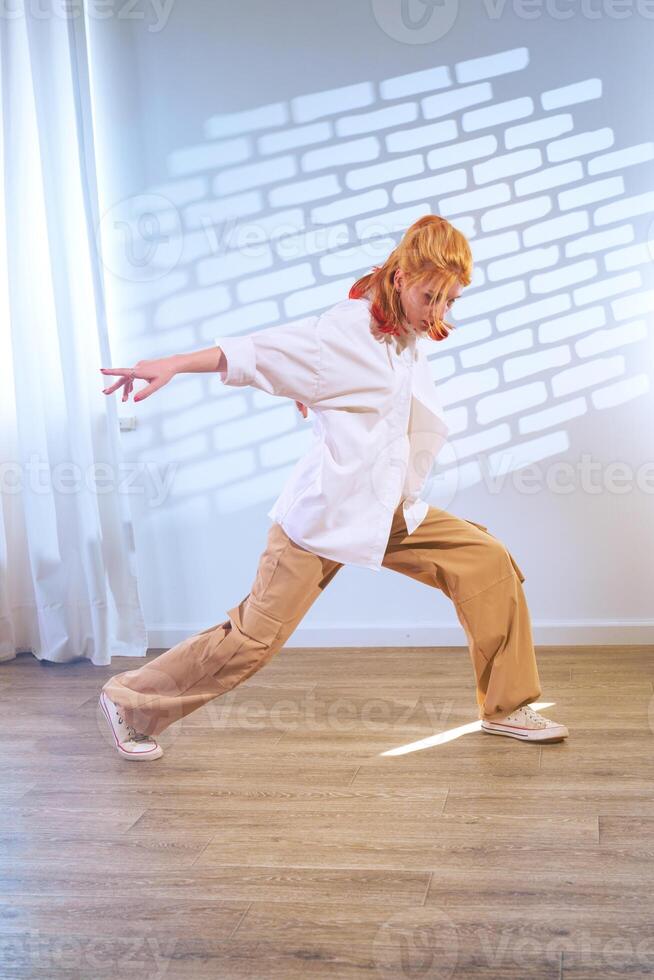 Dancer performing dynamic movement in a spacious studio with soft lighting during a creative practice session photo