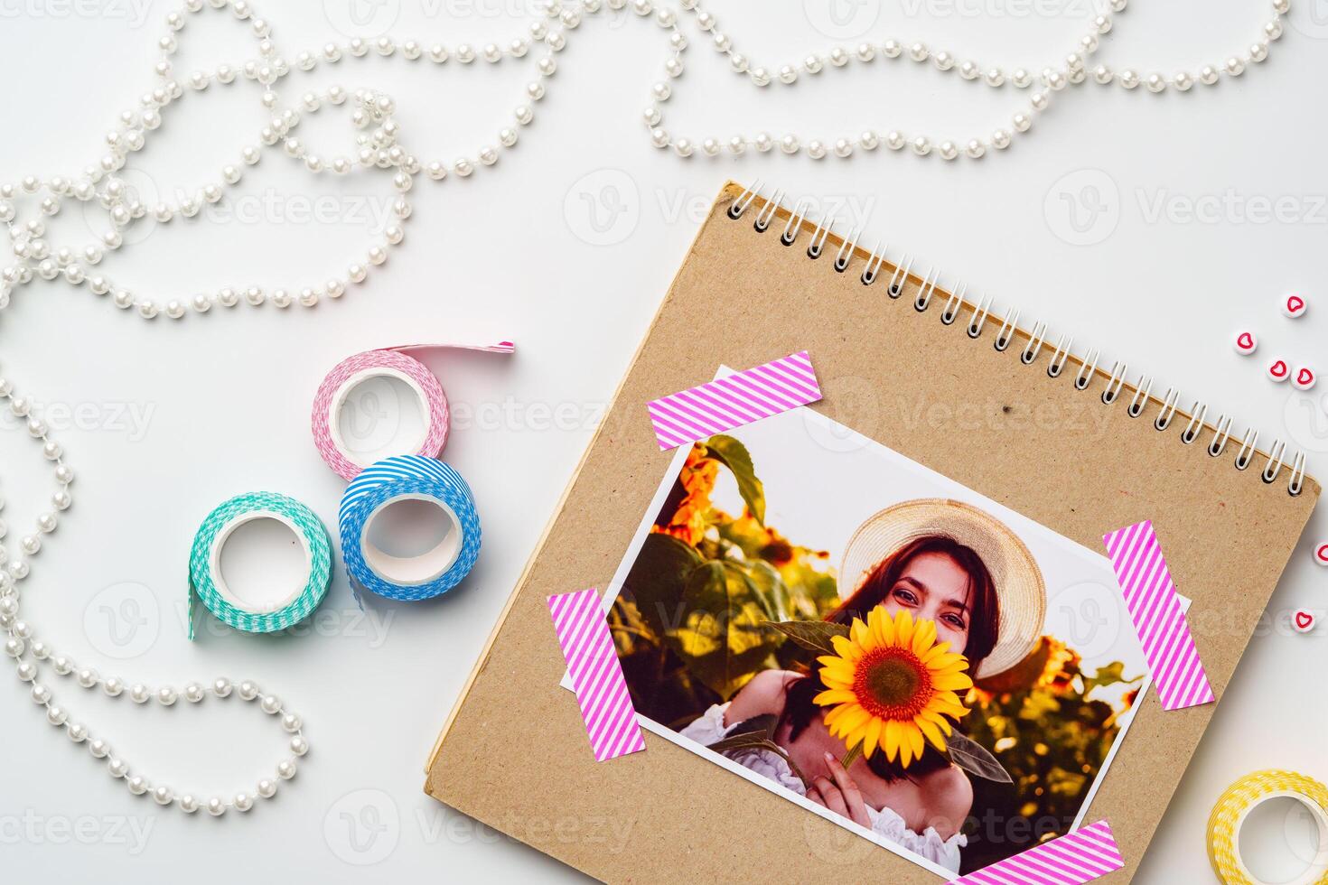 Creative scrapbook layout featuring a woman holding a sunflower with decorative accessories on a clean surface photo
