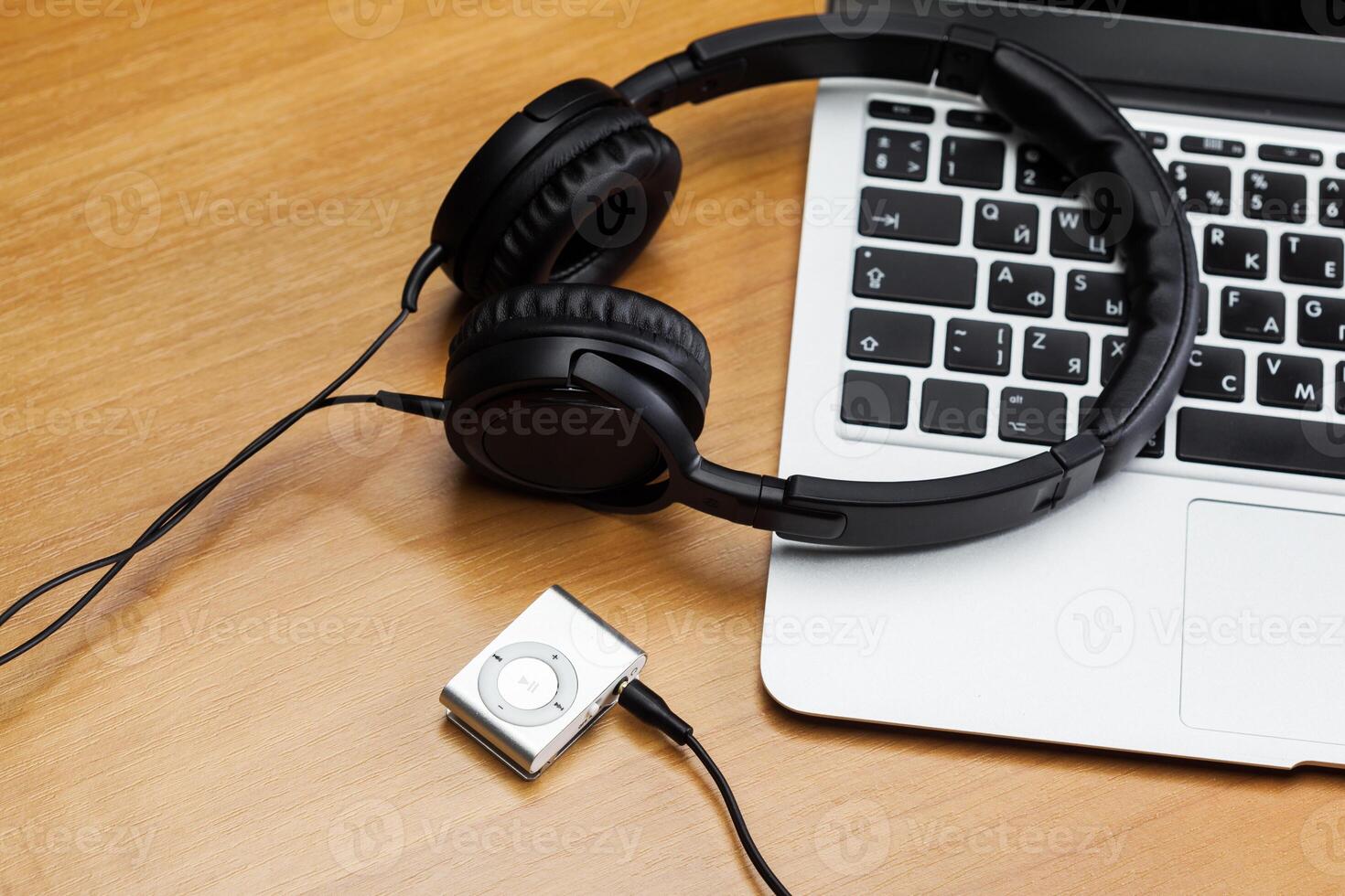 Headphones with laptop on table close up photo