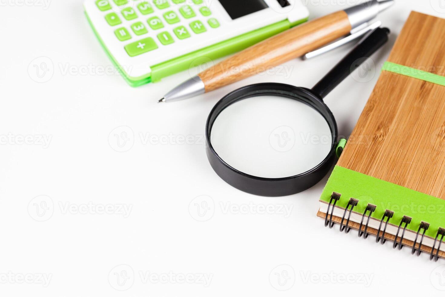 Calculator with a magnifying glass on a white background photo